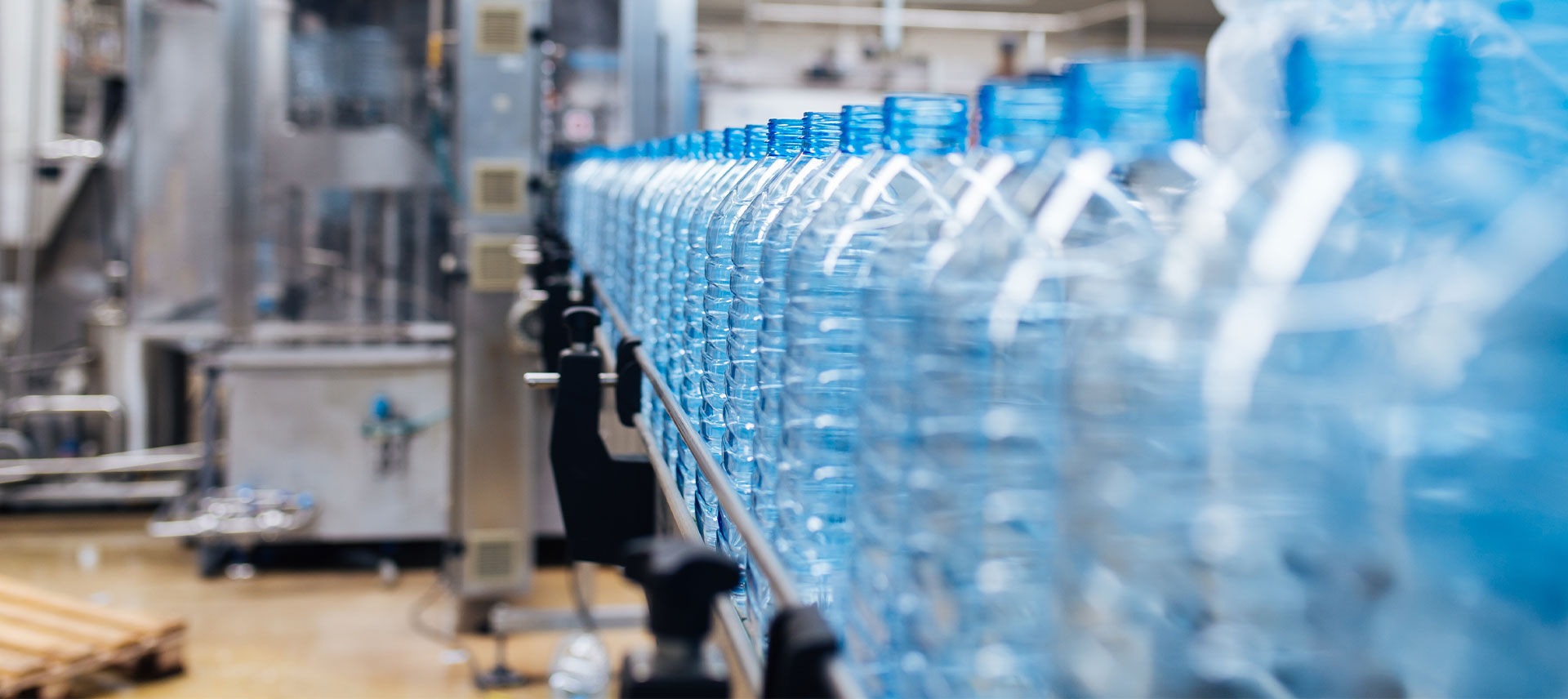 bottling-plant-water-bottling-line-processing-bottling-pure-spring-water-into-blue-bottles-selective-focus